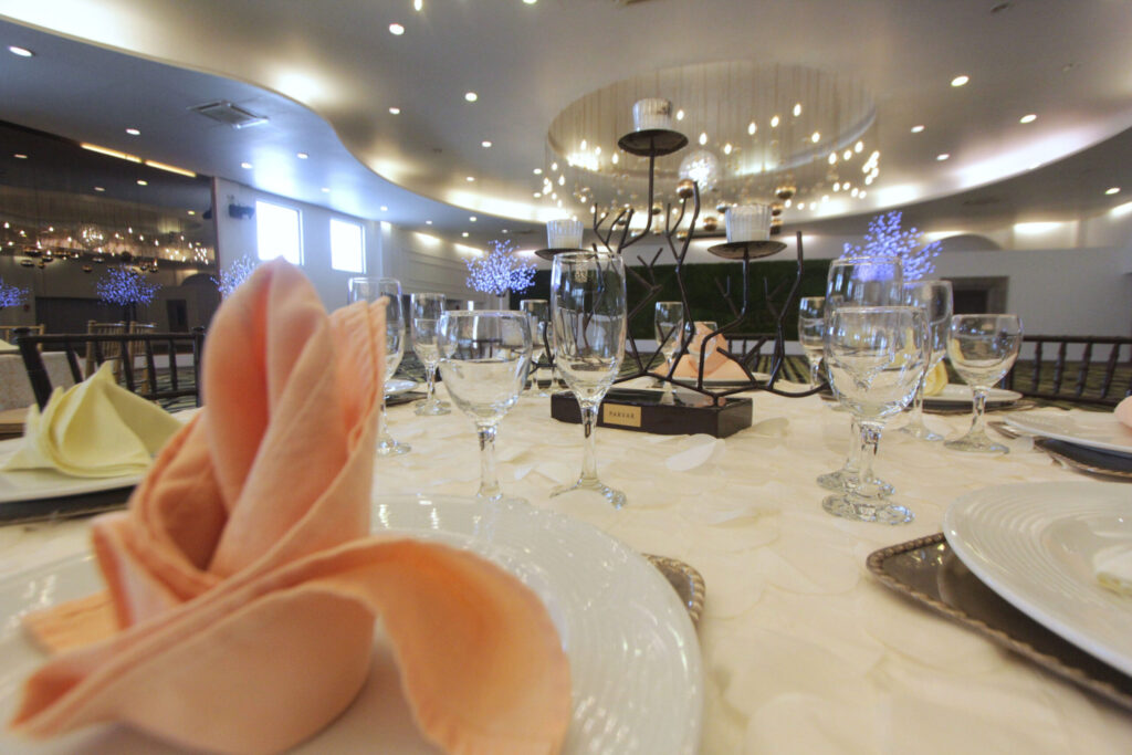 Graduaciones 2026: más eventos pero con menos invitados por familia Salón de fiestas preparado para evento de graduación con mesas decoradas y pocos asistentes