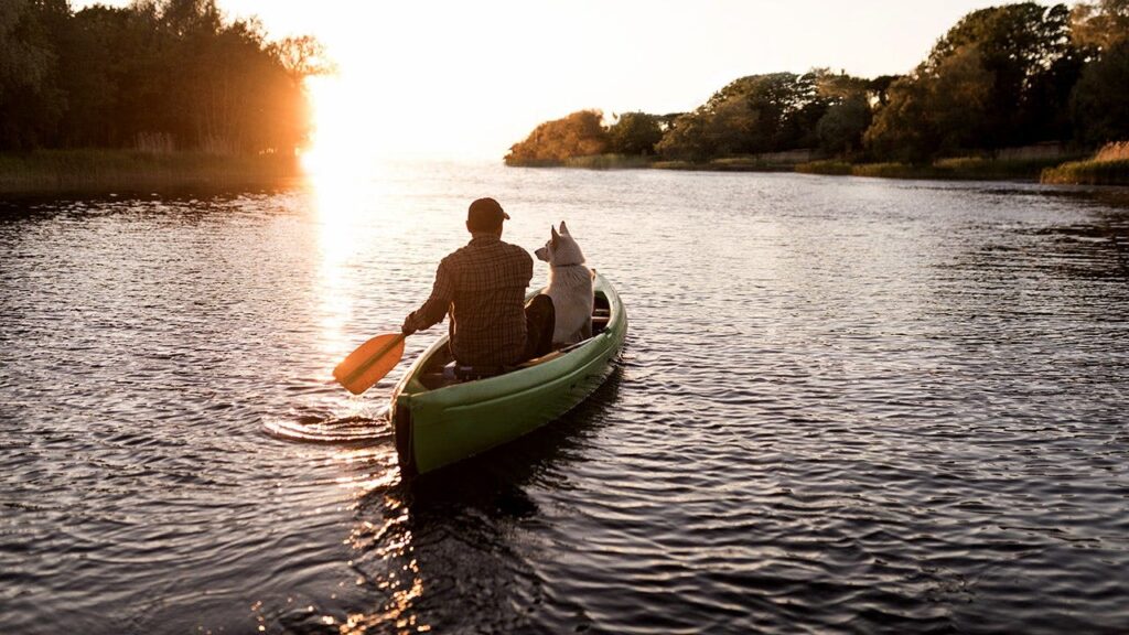 Frank Carter navegando en canoa por el río Missouri junto a su perro golden retriever Amos durante su travesía de 3,200 kilómetros