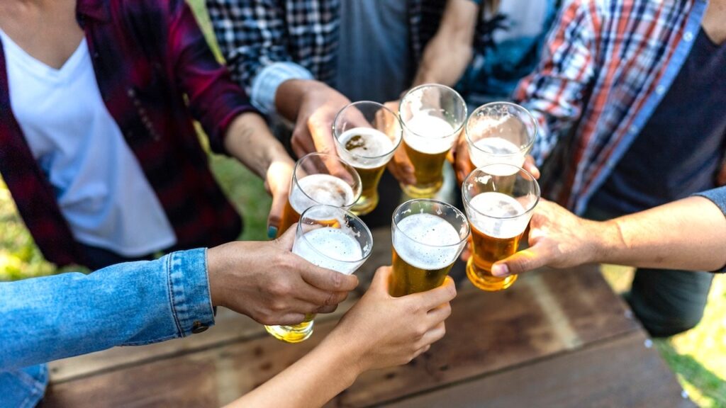 Persona sosteniendo una copa de alcohol, ilustrando el debate sobre consumo diario y alcoholismo
