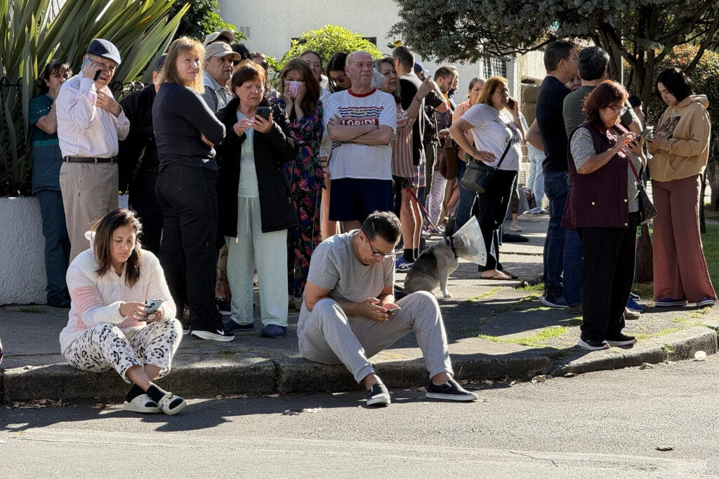 Personas evacuan edificios tras un fuerte temblor este lunes, en Bogotá (Colombia).