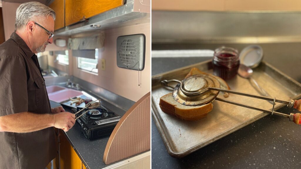 Comida de fogata regresa: recetas vintage conquistan a jóvenes en EE.UU. Pareja preparando comida en fogata de campamento con remolque vintage de fondo