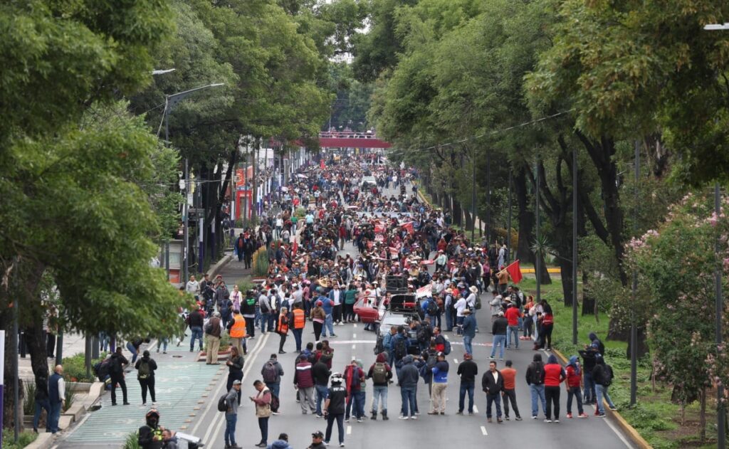Manifestantes marchando por calles de la Ciudad de México con pancartas durante movilización ciudadana