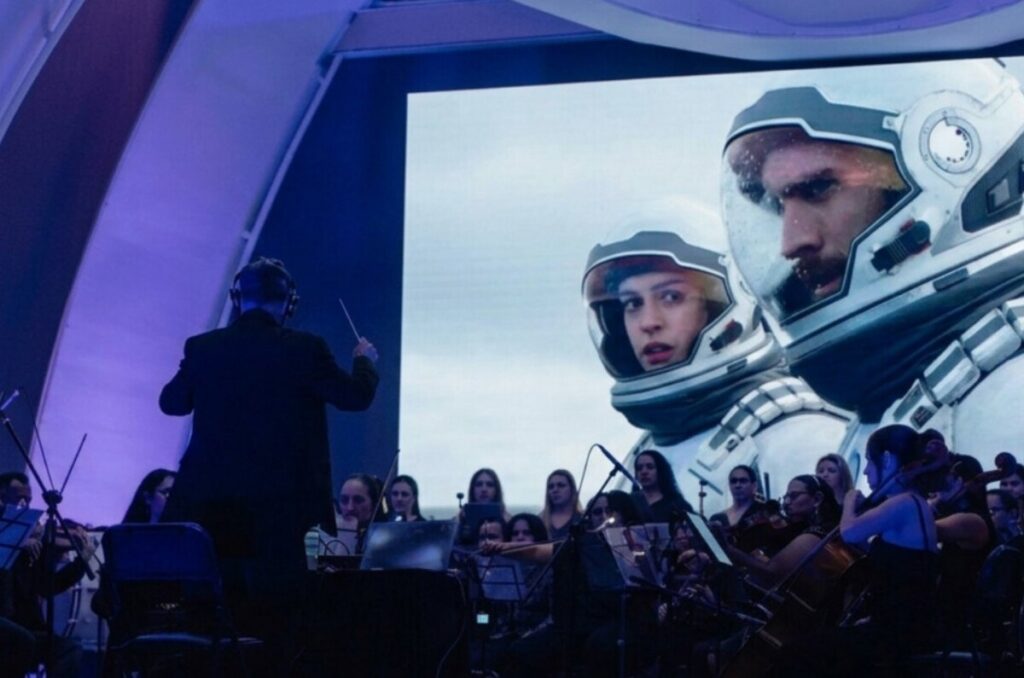 Orquesta sinfónica interpretando la banda sonora de Interstellar con proyecciones de galaxias en el Teatro Balderas